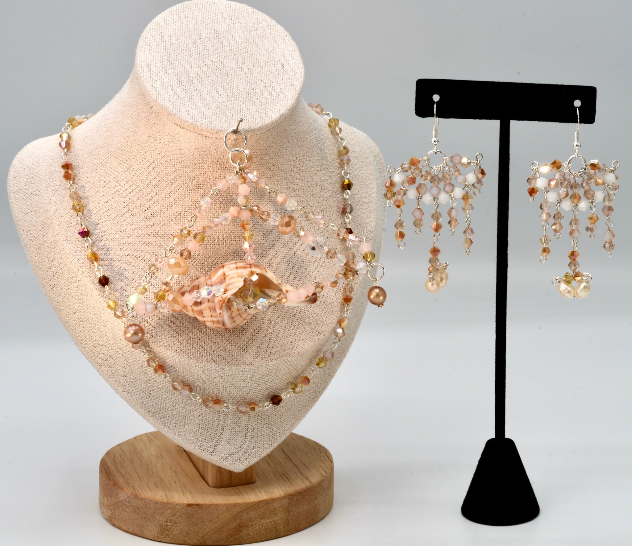 Jewelry set with necklace and earrings on a mannequin and stand.