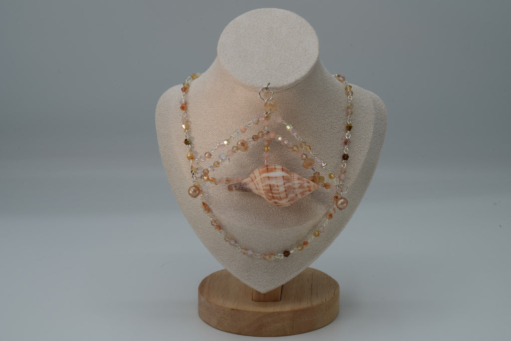 Necklace with seashells on a mannequin bust against a gray background