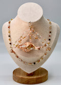 Jewelry set with beads and a shell on a mannequin bust.