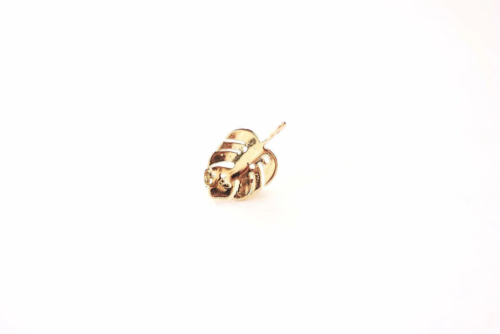 A single gold-colored twisted monarwe LEAF on a solid white background.